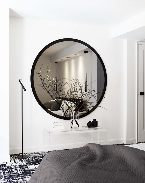 Oversized round black mirror, acrylic bench, black floor lamp, black pendant lights, black and white carpet and white walls Oversized round black mirror, acrylic bench, black floor lamp, black pendant lights, black and white carpet and white walls