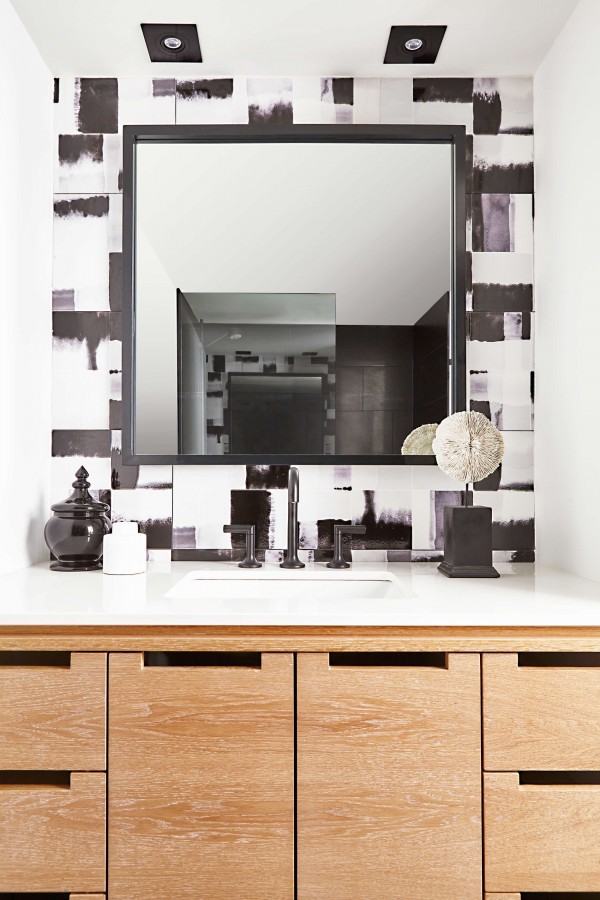 Black and white tile bathroom with black square mirror, limed oak blonde wood vanity, white countertop, white undermount sink and black faucet Black and white tile bathroom with black square mirror, limed oak blonde wood vanity, white countertop, white undermount sink and black faucet