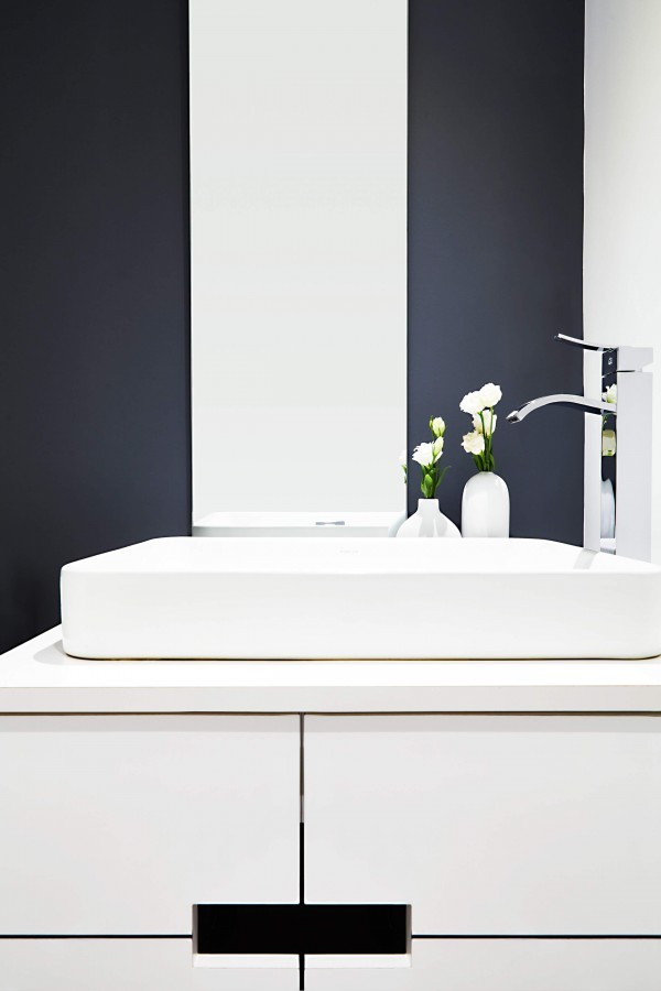 Powder room with white vanity, white vessel sink, chrome faucet, gray walls and thin mirror Powder room with white vanity, white vessel sink, chrome faucet, gray walls and thin mirror