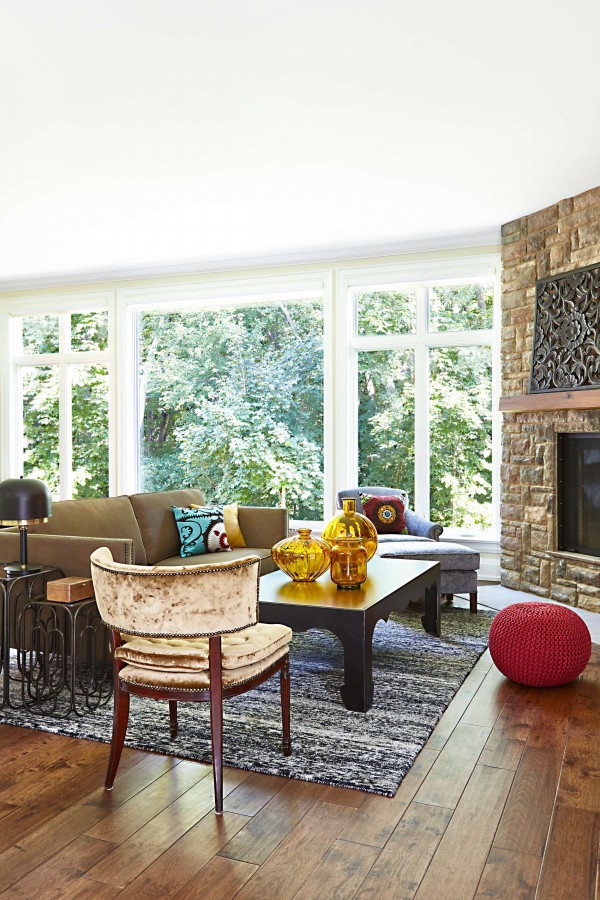 Velvet chair, hardwood floor, red pouf ottoman, corner fireplace, black and white rug, brown sofa, blue velvet lounge chair with ottoman Velvet chair, hardwood floor, red pouf ottoman, corner fireplace, black and white rug, brown sofa, blue velvet lounge chair with ottoman