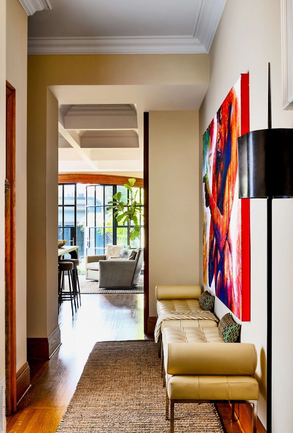 Hallway with leather benches, black floor lamp, red oversized art, and sisal rug Hallway with leather benches, black floor lamp, red oversized art, and sisal rug