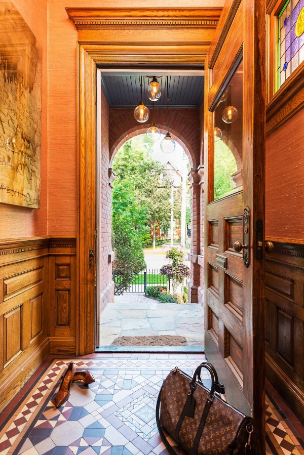 Tiled front entranceway with wood door, wood paneled wall, stained glass window, and custom glass globe outdoor light Tiled front entranceway with wood door, wood paneled wall, stained glass window, and custom glass globe outdoor light