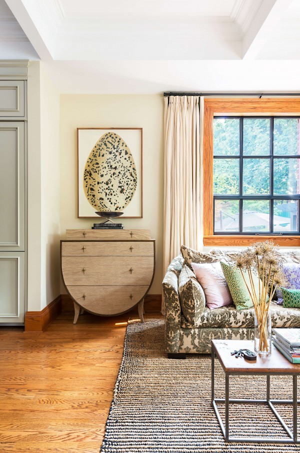 Neutral living space with egg artwork, wood side table, sofa, original hardwood floor and sisal rug Neutral living space with egg artwork, wood side table, sofa, original hardwood floor and sisal rug