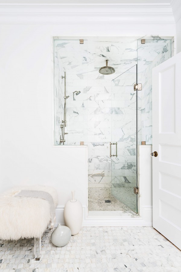 Stunning white marble shower, glass panel shower door, chrome rainfall shower head, fur bench, and white mosaic floor Stunning white marble shower, glass panel shower door, chrome rainfall shower head, fur bench, and white mosaic floor
