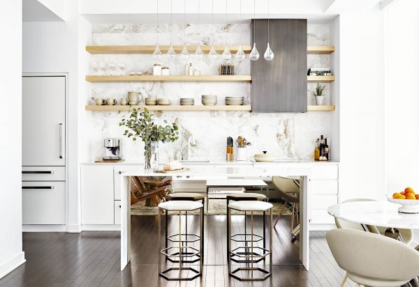 Custom kitchen with beautiful hex counter stools, white cabinets, white walls, panel ready appliances, marble large scale backsplash tile, white quartz countertop, limed oak open shelves, dark hardwood flooring, metal custom hood, glass pendant light, mirrored waterfall island, marble table and beige dining chairs Custom kitchen with beautiful hex counter stools, white cabinets, white walls, panel ready appliances, marble large scale backsplash tile, white quartz countertop, limed oak open shelves, dark hardwood flooring, metal custom hood, glass pendant light, mirrored waterfall island, marble table and beige dining chairs