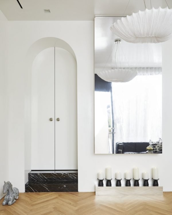 Toronto Interior Design Group, TIDG, TIDG boutique, with mirror, candles, hardwood floor, decorative horse, silk ceiling fixture, arches, arched doors, high gloss walls, Chantilly Lace paint, white walls, herringbone floor, blonde wood, oak wood, marble stairs, nero marquina